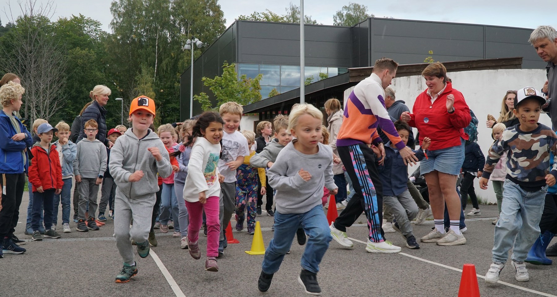 Mange barn er samlet for skoleløp for TV-aksjonen. Kjegler markerer hvor de skal løpe.