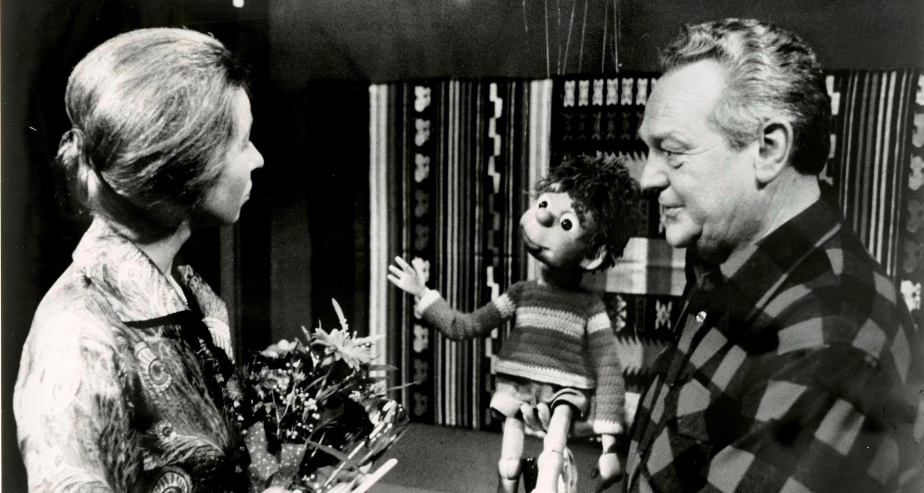 Svarthvitt bilde av TV-aksjonen i 1978, med en kvinne og Rolf Kirkevaag med dukken Titten Tei
