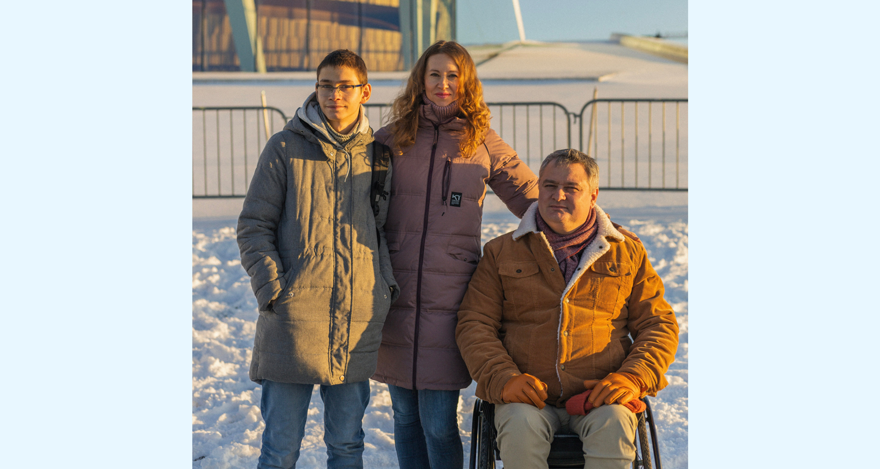 En mann sitter i rullestol foran operaen i Oslo en vinterdag. Ved siden av står en kvinne og en gutt på 16 år. 